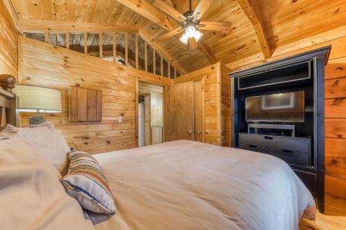 a bedroom with a bed and a flat screen tv at Calvery Cabin in Sevierville