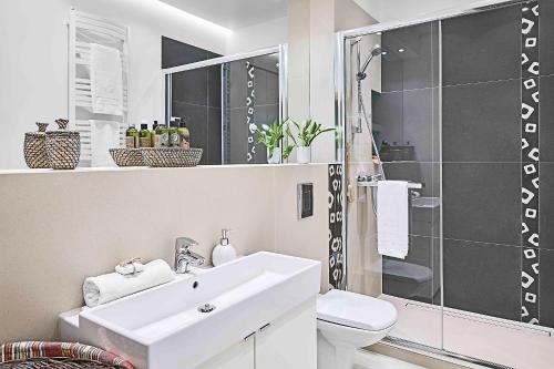 a white bathroom with a sink and a shower at IRS ROYAL APARTMENTS Apartamenty IRS Nadmorski Dwór in Gdańsk