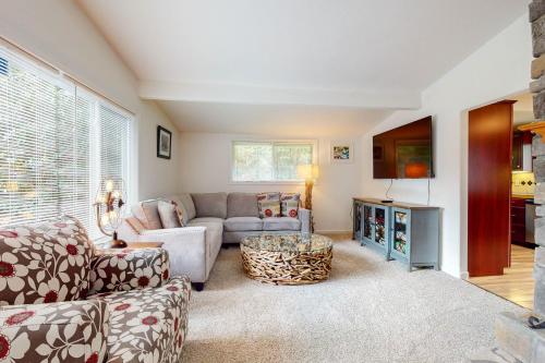 a living room with a couch and a tv at Abalone Rose in Newport