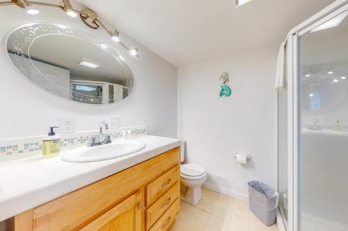 a bathroom with a sink and a toilet and a mirror at Abalone Rose in Newport