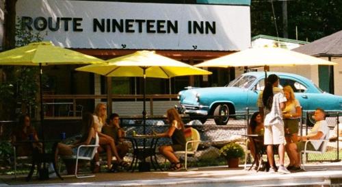 a group of people sitting at a table with umbrellas at Route 19 Inn in Maggie Valley