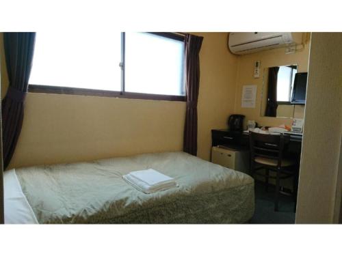 a bedroom with a bed and a desk and a window at City Inn Nishi Tanabe / Vacation STAY 78534 in Osaka