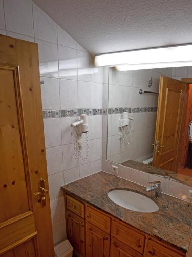 a bathroom with a sink and a mirror at Ferienwohnungen am Kurpark in Roßhaupten