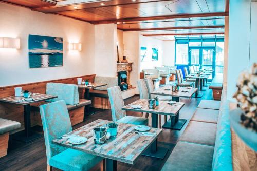 un restaurante con mesas de madera y sillas azules en Hotel Schwertfirm, en Karlsfeld