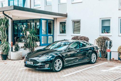 a black car parked in front of a building at Hotel Schwertfirm in Karlsfeld
