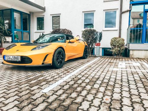 a yellow sports car parked in front of a building at Hotel Schwertfirm in Karlsfeld
