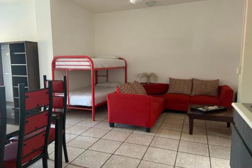 a living room with a red couch and bunk beds at Hotel Posada Doña Rubino in Mazatlán