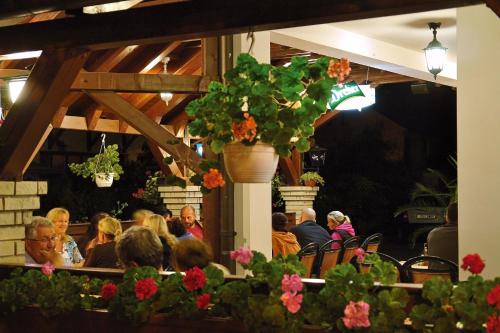 a group of people sitting in a restaurant at Korona Pension and Restaurant in Hévíz
