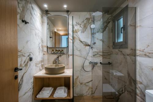a bathroom with a sink and a shower at Riviera Boutique Hotel in Stalís