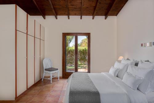 VagiaにあるMarina's Paradise Summer Houseのベッドルーム1室(ベッド1台、椅子、窓付)
