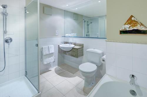 een badkamer met een toilet, een wastafel en een douche bij Heritage Queenstown in Queenstown