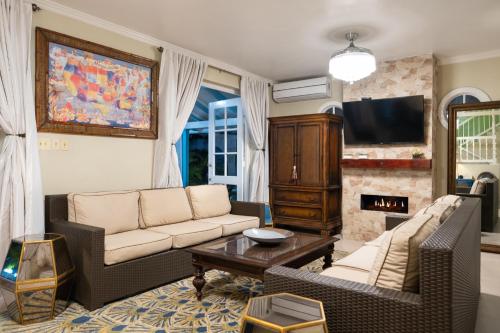 a living room with two couches and a fireplace at Edgewater Beach Villa - Beach Front, Close to All Attractions in St Mary