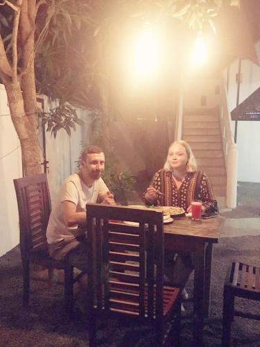 a man and a woman sitting at a table at Sunnyplace Guest Mirissa in Mirissa