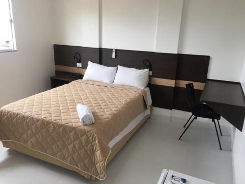 1 dormitorio con 1 cama grande y escritorio en Executive Hotel, en Lucas do Rio Verde