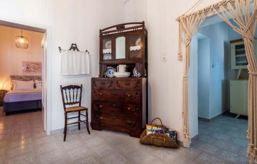 a room with a dresser and a chair and a mirror at Giorgantis House & Studio in Triovasálos