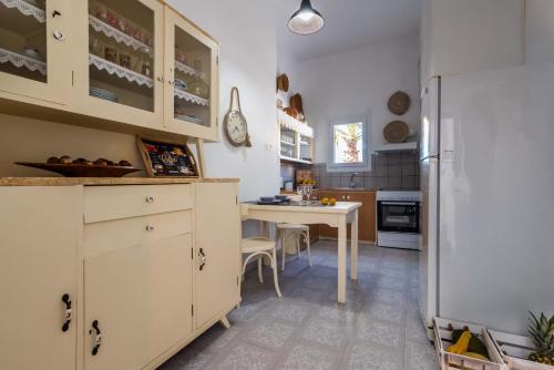 a kitchen with a table and a white refrigerator at Giorgantis House & Studio in Triovasálos