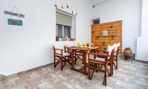 a dining room with a wooden table and chairs at Giorgantis House & Studio in Triovasálos