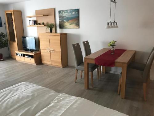 a living room with a dining room table and a television at Steiner Strandappartements Appartement 304 Seeseite in Stein
