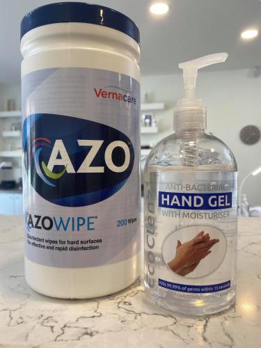 a bottle of hand gel next to a bottle of water at Fab Apartment in Loughborough