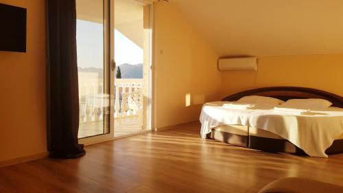 a bedroom with a bed and a balcony with a view at Monte Liza in Dobra Voda