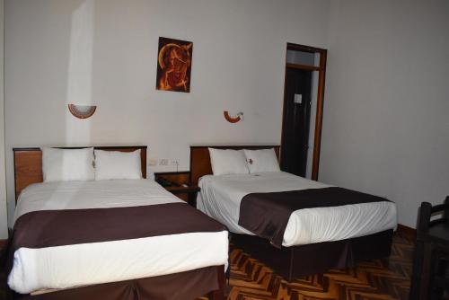 Łóżko lub łóżka w pokoju w obiekcie Colonial Plaza Hotel