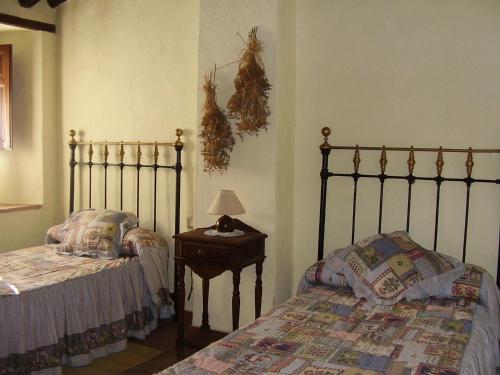 a bedroom with two beds and a table with a lamp at Casa El Menúo in Parauta