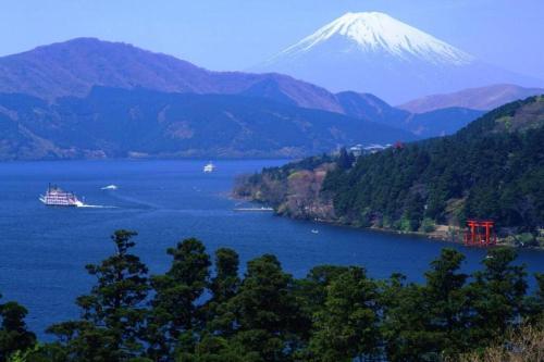 a cruise ship in a lake with a mountain in the background at Chalet Itomic M in Hakone