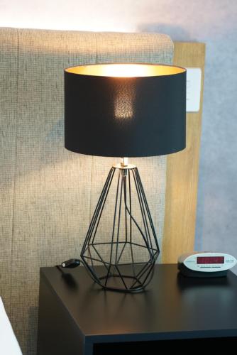 a black lamp sitting on a table with a clock at Jephson Hotel & Apartments in Brisbane