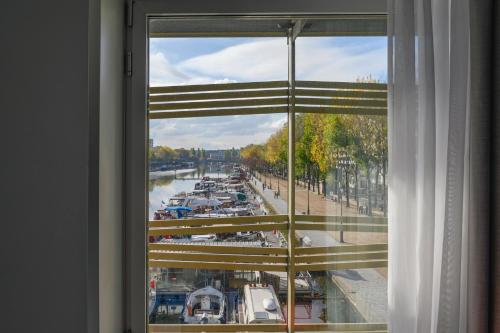 a window with a view of a marina at Holiday Inn Express Paris-Canal De La Villette by IHG in Paris