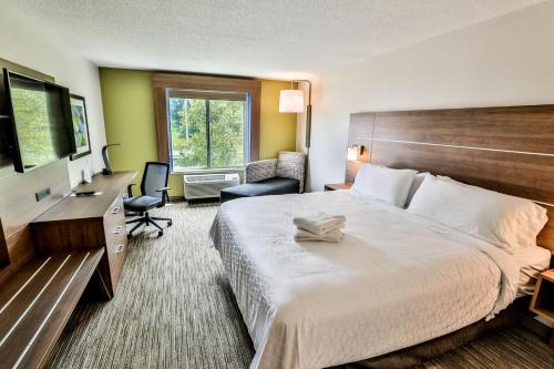 a hotel room with a large bed and a desk at Holiday Inn Express Hotel & Suites Dickson by IHG in Dickson