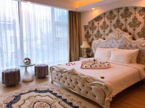 a bedroom with a large bed with a large window at Golden Rose Hotel in Da Nang