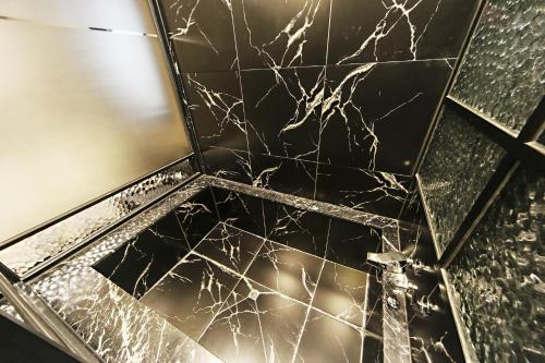 a bathroom with a black marble floor with a spiderweb at Masan Almond Hotel in Changwon