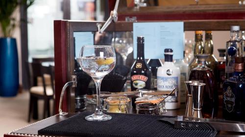 a glass of wine sitting on a table with bottles of wine at Staybridge Suites Newcastle by IHG in Newcastle upon Tyne