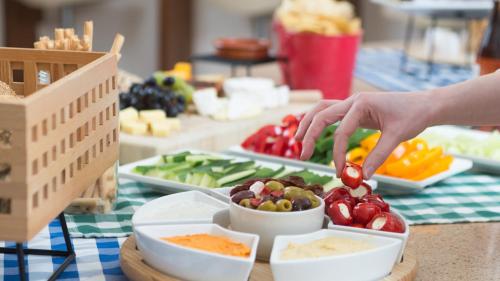 a person is spooning food into a bowl of vegetables at Staybridge Suites Newcastle by IHG in Newcastle upon Tyne