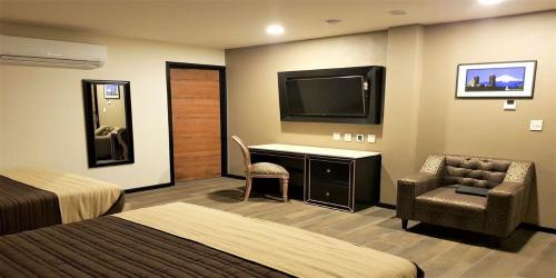 a hotel room with a bed and a desk and a television at Mansion Azul Cholula in Cholula