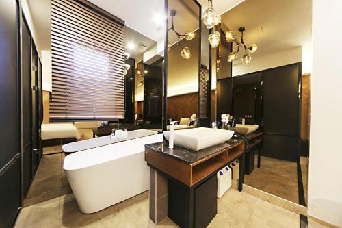 a large bathroom with a large tub and a sink at Masan Almond Hotel in Changwon