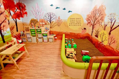 a childs play area with a mural of a playground at Just Sleep Hualien ZhongZheng in Hualien City