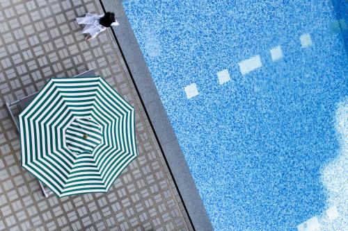 an overhead view of an umbrella next to a swimming pool at Jazzotel Bangkok- SHA Extra Plus in Bangkok