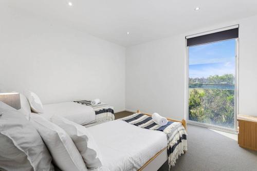 - une chambre avec 2 lits et une grande fenêtre dans l'établissement DREW Golfers Delight close to St Andrews Beach, à Fingal