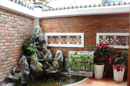 a fish pond in a brick wall with a water feature at Hue 1962 INN in Hue