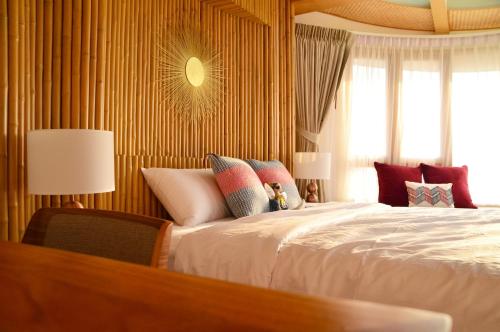 七岩的住宿－Pannana Cha-am，一间卧室设有一张大床和一个窗户。