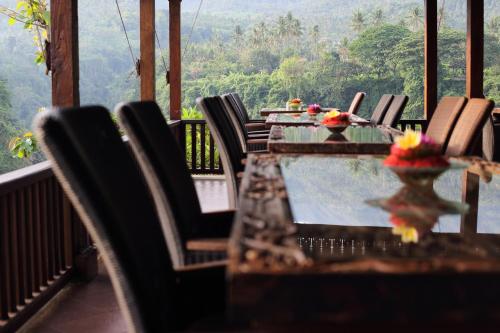 a table and chairs on a balcony with a view at Shanti Natural Panorama View Hotel in Singaraja