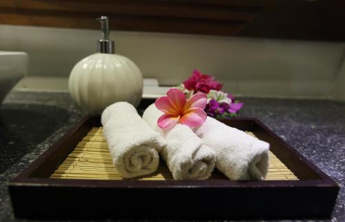 a tray with towels and flowers on a bathroom counter at Shanti Natural Panorama View Hotel in Singaraja