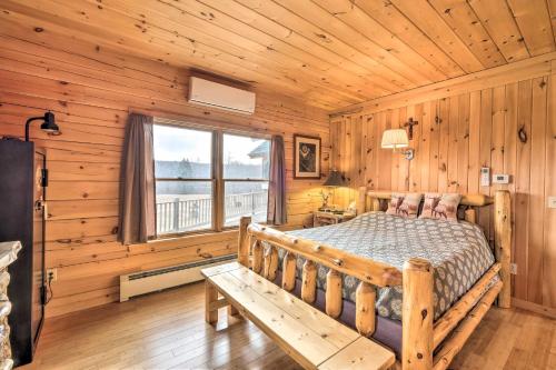 a bedroom with a bed in a wooden cabin at Family-Friendly Troy Getaway with Furnished Deck! in Unity