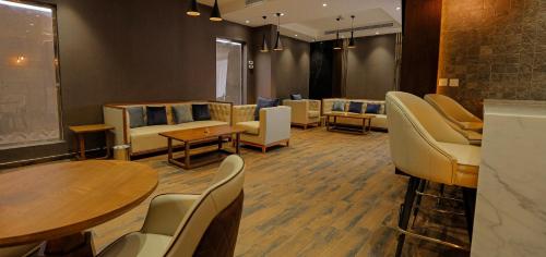 uma sala de espera com sofás, mesas e cadeiras em SUITS HOTEl تشغيل مؤسسه سويت لتشغيل الفنادق em Jidá