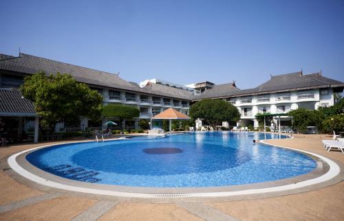 a large swimming pool in front of a building at Silversand Villa Hotel in Jomtien Beach