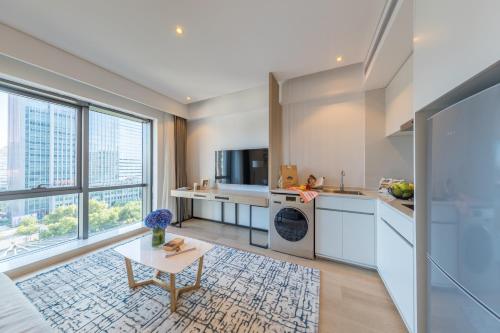 a kitchen with white cabinets and a table at Sincere Residence Changfeng - Changfeng Ecological Business District - Near Exit 3 of Changfeng Park Station on Subway Line 15 in Shanghai