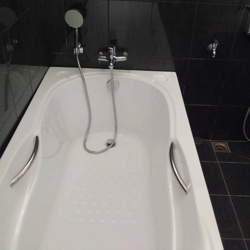 a white bath tub with a shower in a bathroom at Captain's Cabin Resort - Naval Heritage (Swimming Pool) in Kota Bharu