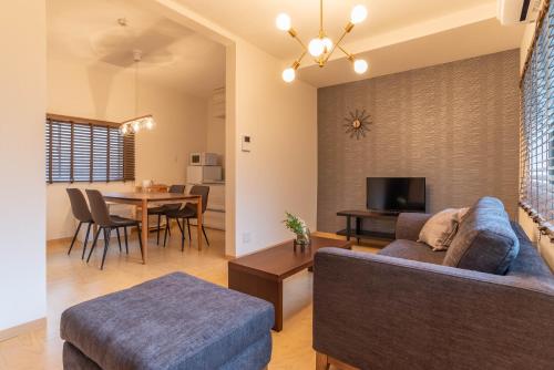a living room with a couch and a dining room at Tino Mizuki in Osaka