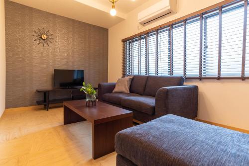 a living room with a couch and a tv at Tino Mizuki in Osaka